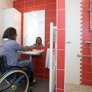 handicapé en fauteuil roulant prés d'un lavabo